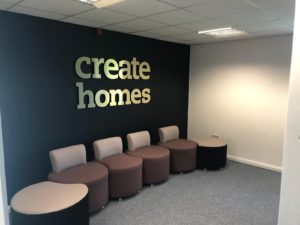 Create Homes Waiting Room with Create Homes gold signage placed above seating